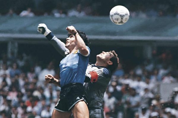 MEXICO CITY, MEXICO - JUNE 22: Diego Maradona of Argentina uses his hand to score the first goal of his team during a 1986 FIFA World Cup Quarter Final match between Argentina and England at Azteca Stadium on June 22, 1986 in Mexico City, Mexico. Maradona later claimed that the goal was scored by 'The Hand Of God'. (Photo by Archivo El Grafico/Getty Images)