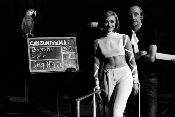 Italian dancer and presenter Raffaella Carrà in an evening dress showing her navel in the studio of Canzonissima with broadcast director Romolo Siena. Rome, Teatro delle Vittorie, 1970. (Photo by Mondadori Portfolio by Getty Images)